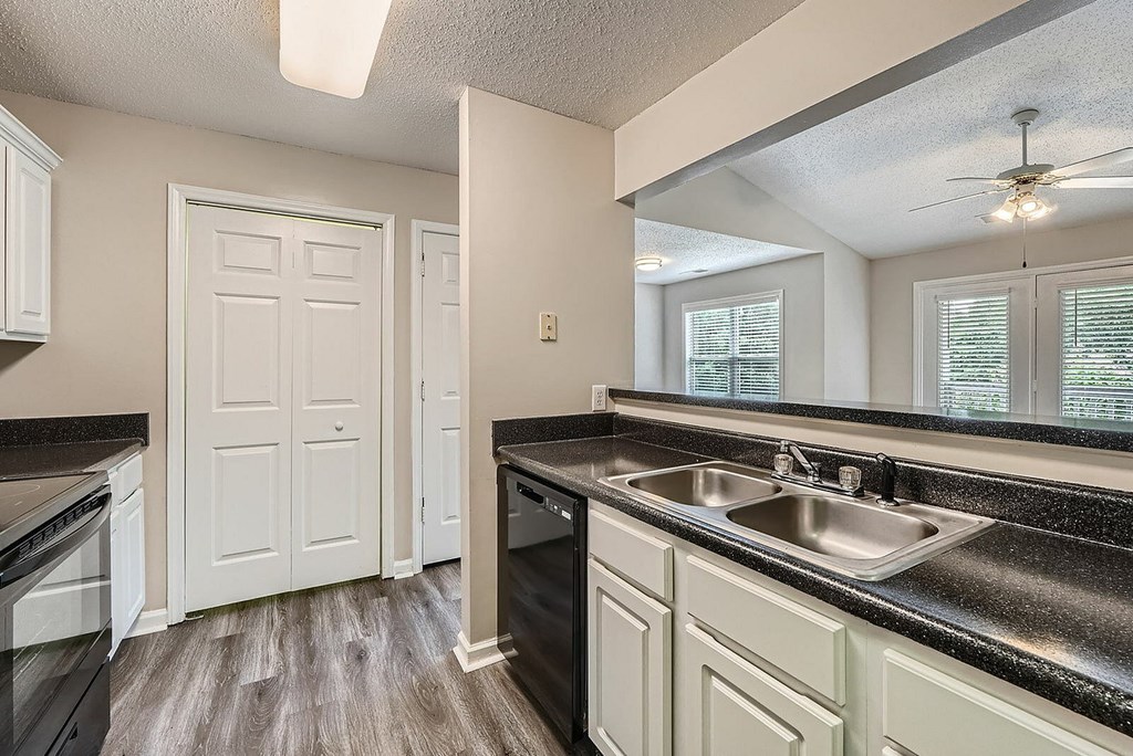 A kitchen with black countertops and white cabinets.