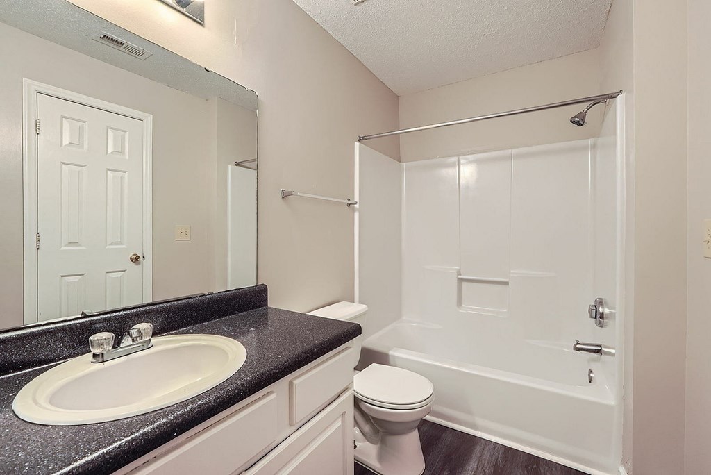 A bathroom with a sink, toilet and shower.