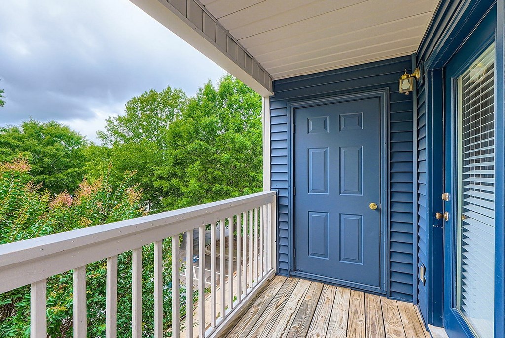 A blue door is on the right side of a white railing.