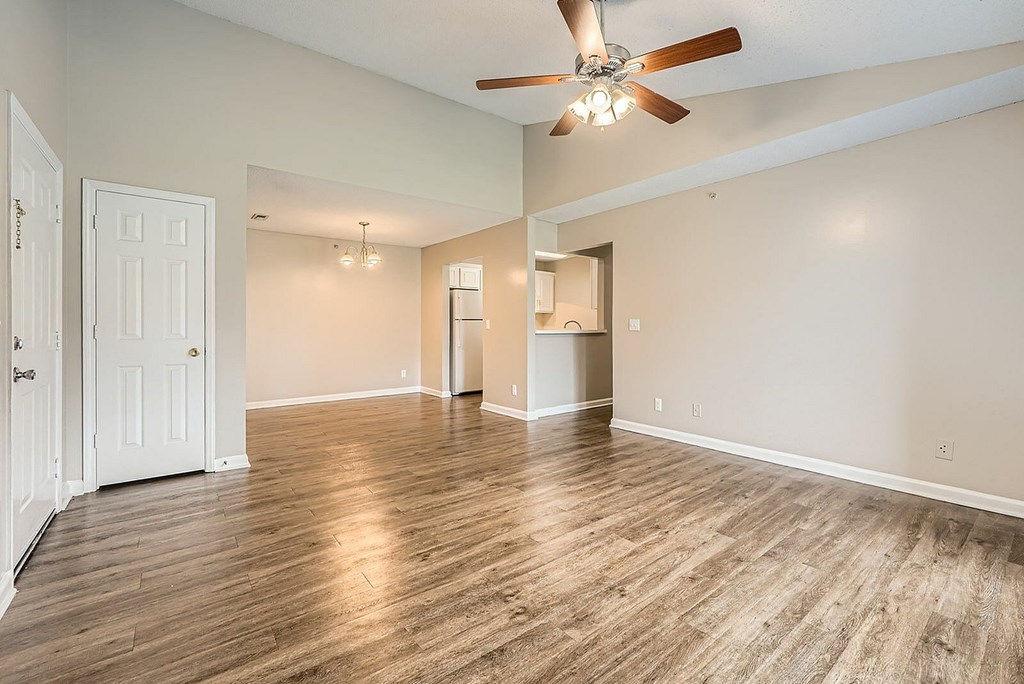 A room with a ceiling fan and wooden flooring.