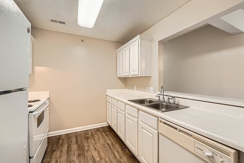 A kitchen with white appliances and cabinets.