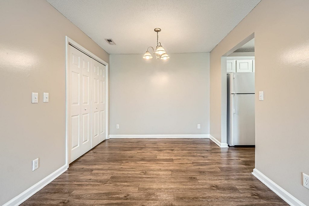 A room with a wooden floor and a white door.
