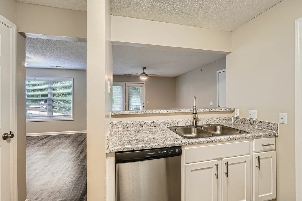 A kitchen with a marble countertop and white cabinets.