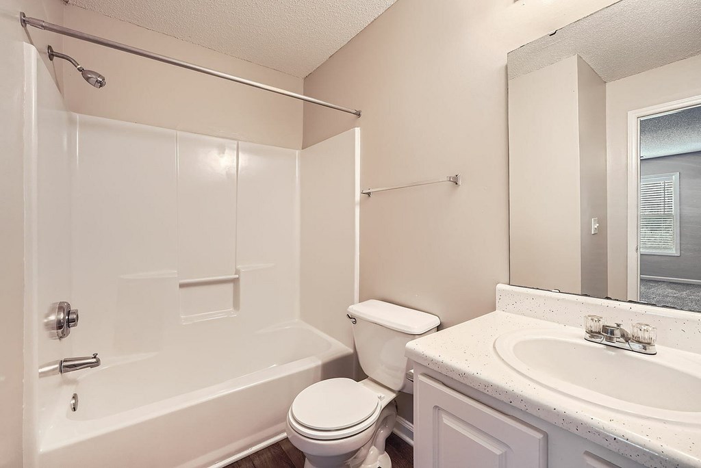 A white bathroom with a toilet, sink, and bathtub.