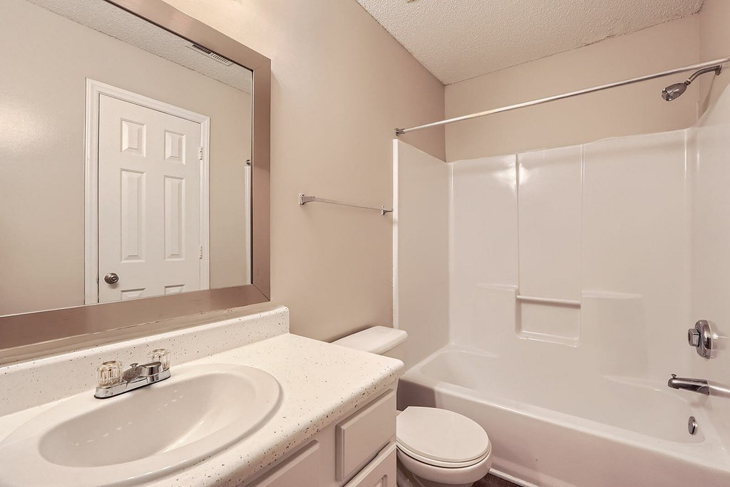 A bathroom with a white sink, toilet, and bathtub.