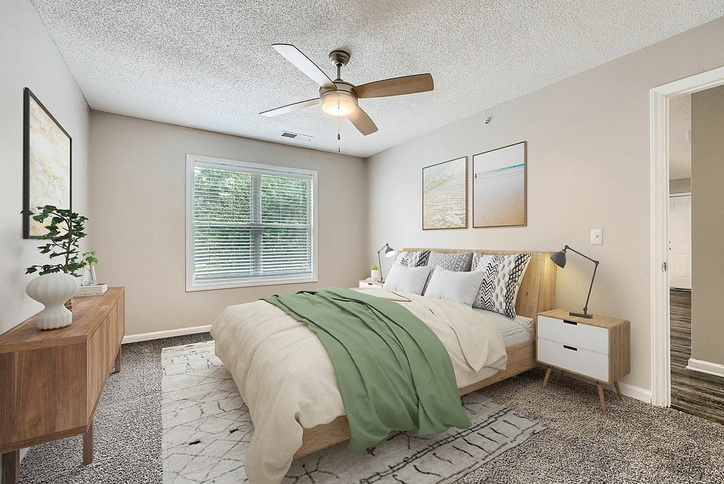 A bedroom with a bed, nightstand, and a ceiling fan.