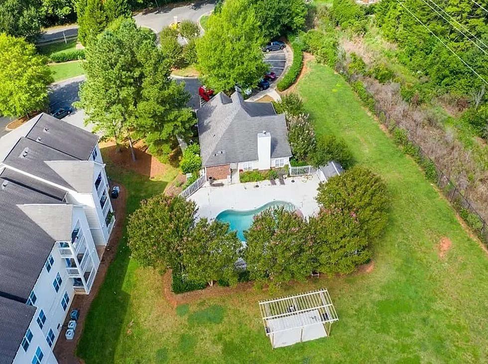 A bird's eye view of a house with a pool and a tree.