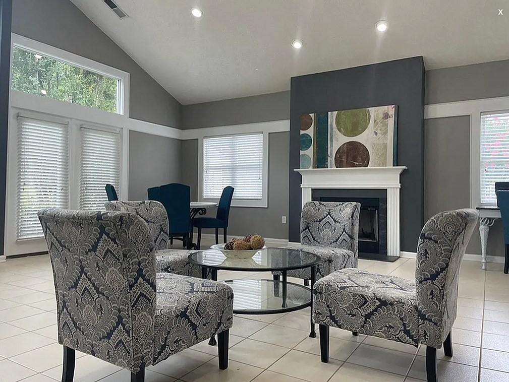 A living room with a fireplace and a glass table.