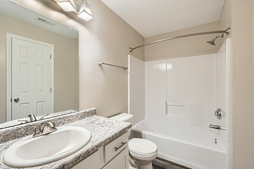 A white bathroom with a sink, toilet, and bathtub.