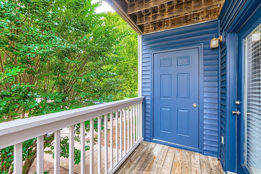 A blue door is on the porch of a house.