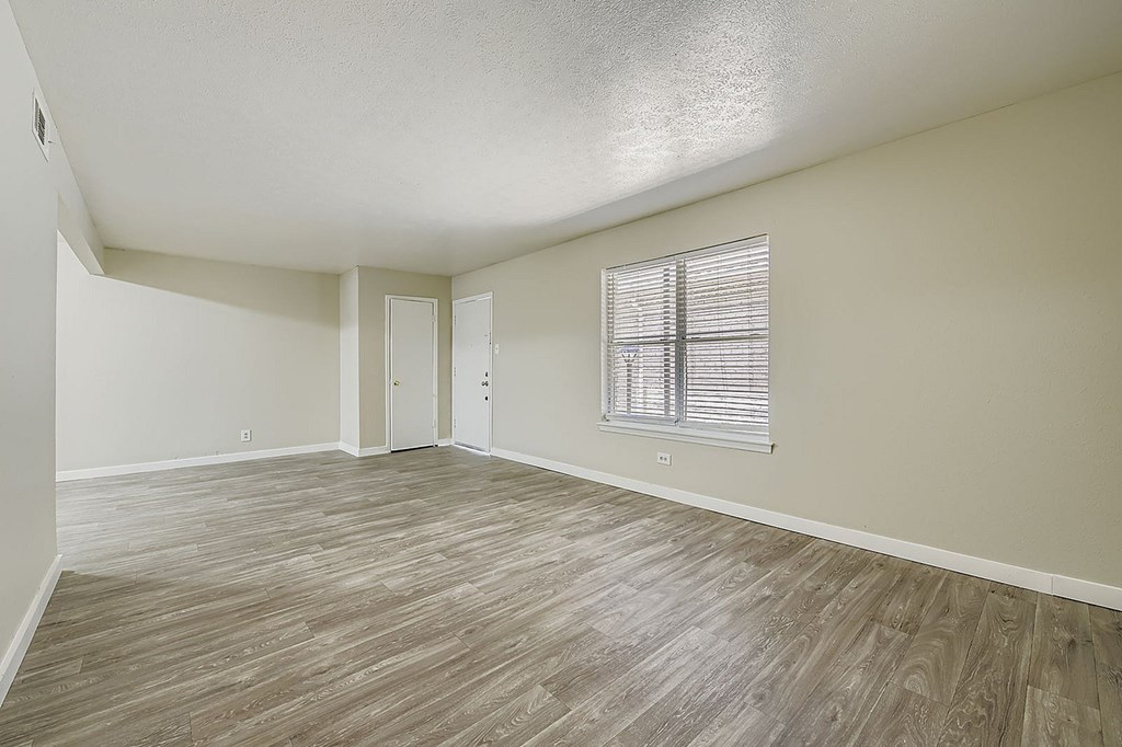 A room with a window and wooden flooring.