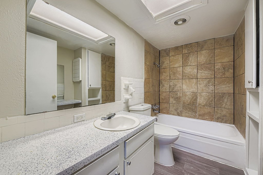 A bathroom with a toilet, sink, and bathtub.