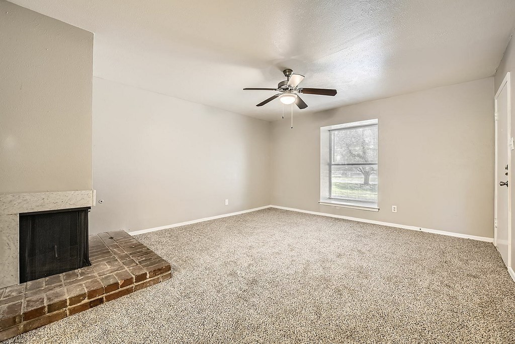A room with a fireplace and a ceiling fan.
