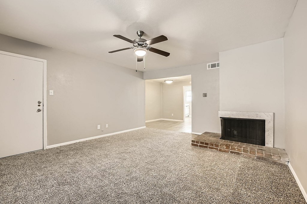 A room with a fireplace and a ceiling fan.