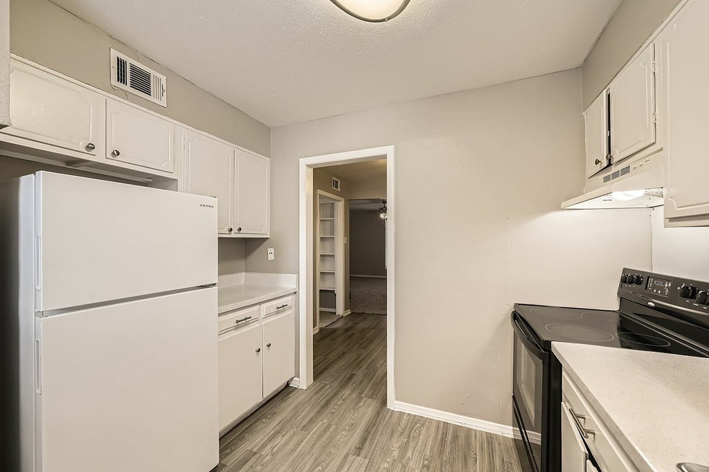 A kitchen with white appliances and cabinets.