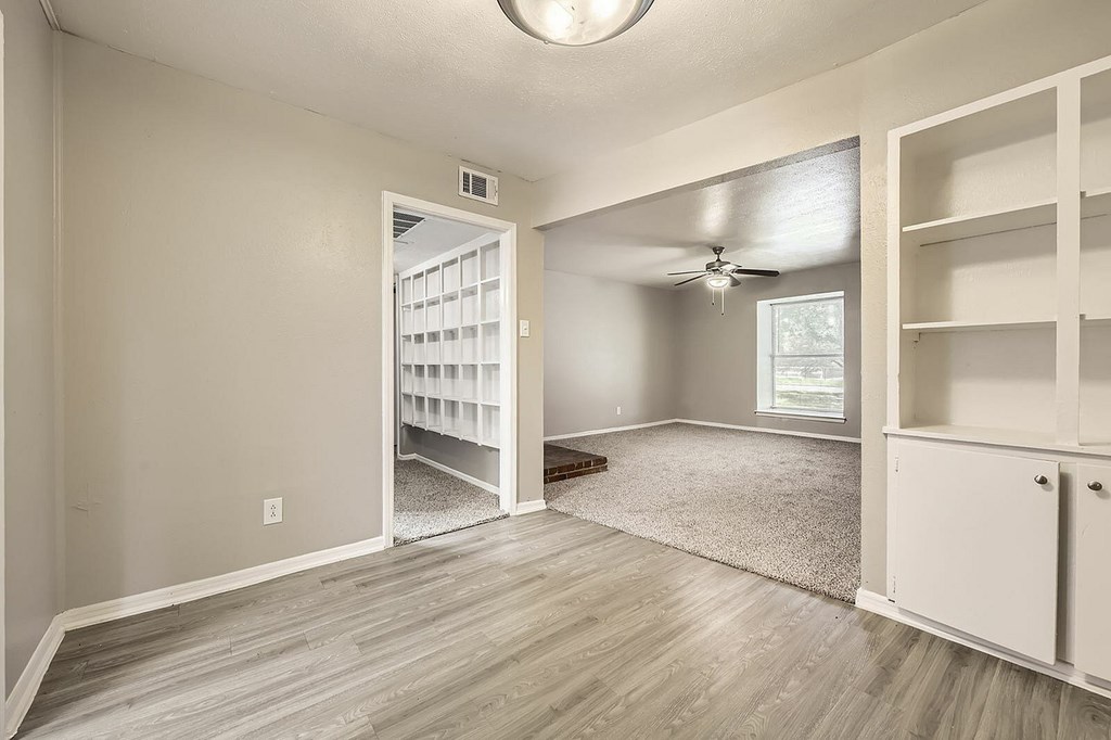 A room with a ceiling fan and a large open door.