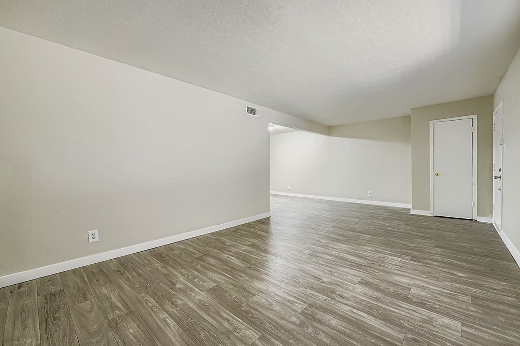 A room with wooden flooring and white walls.