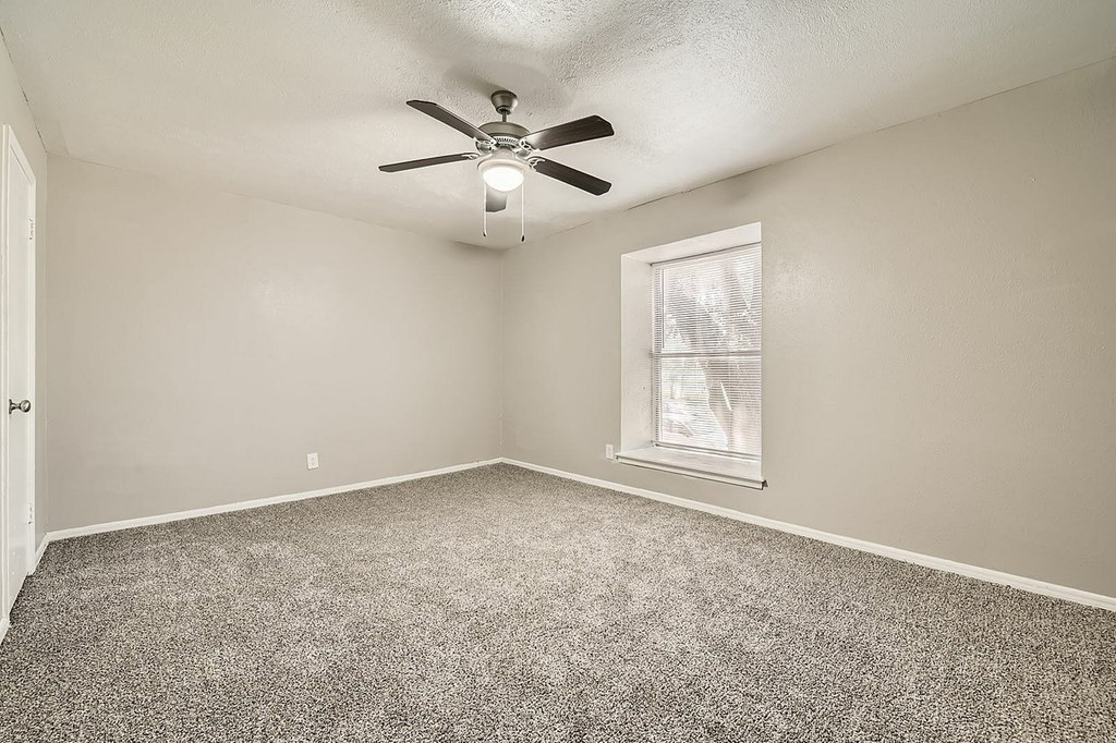 A room with a ceiling fan and a window.