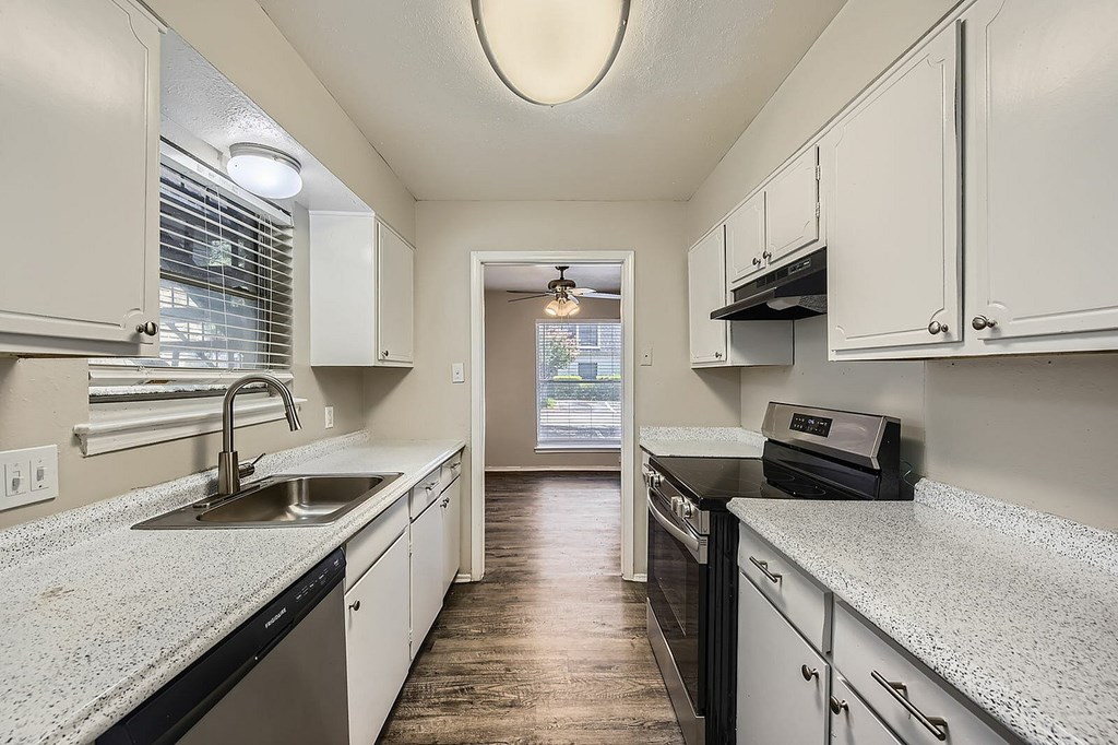 A kitchen with white cabinets and a black stove top oven.