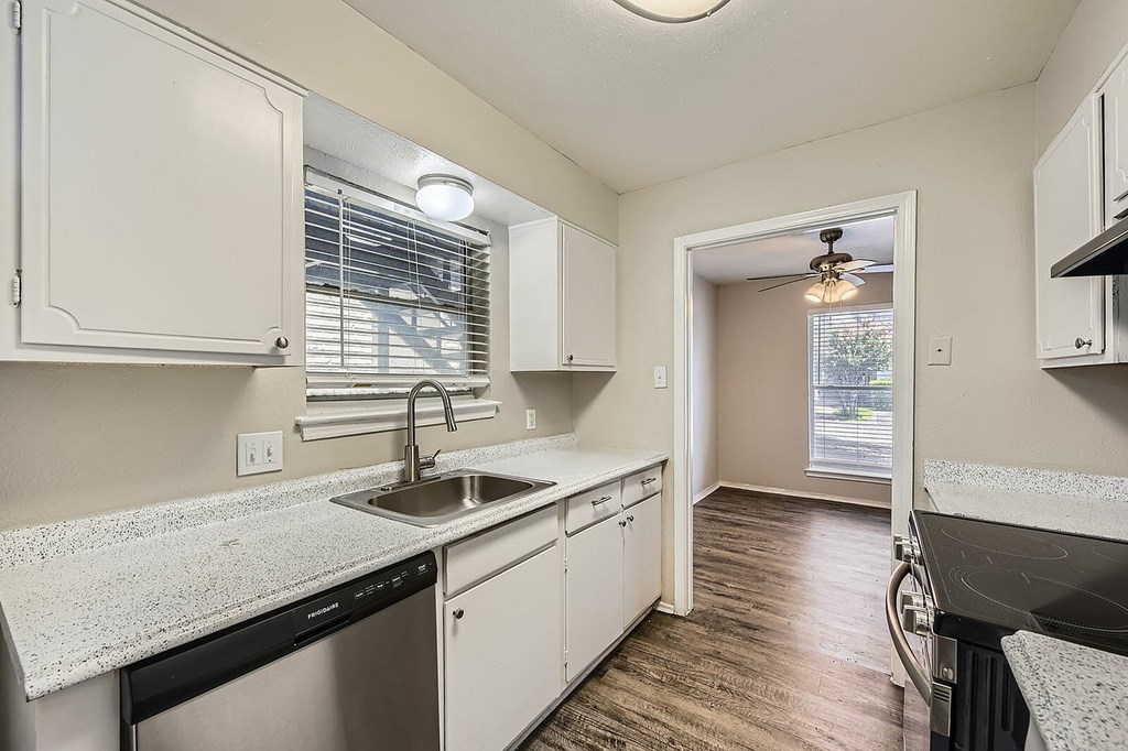 A kitchen with white cabinets and a granite countertop.