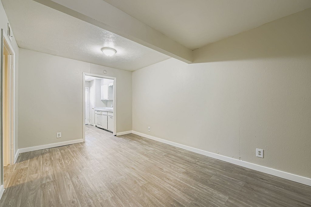 A room with light wood flooring and white walls.