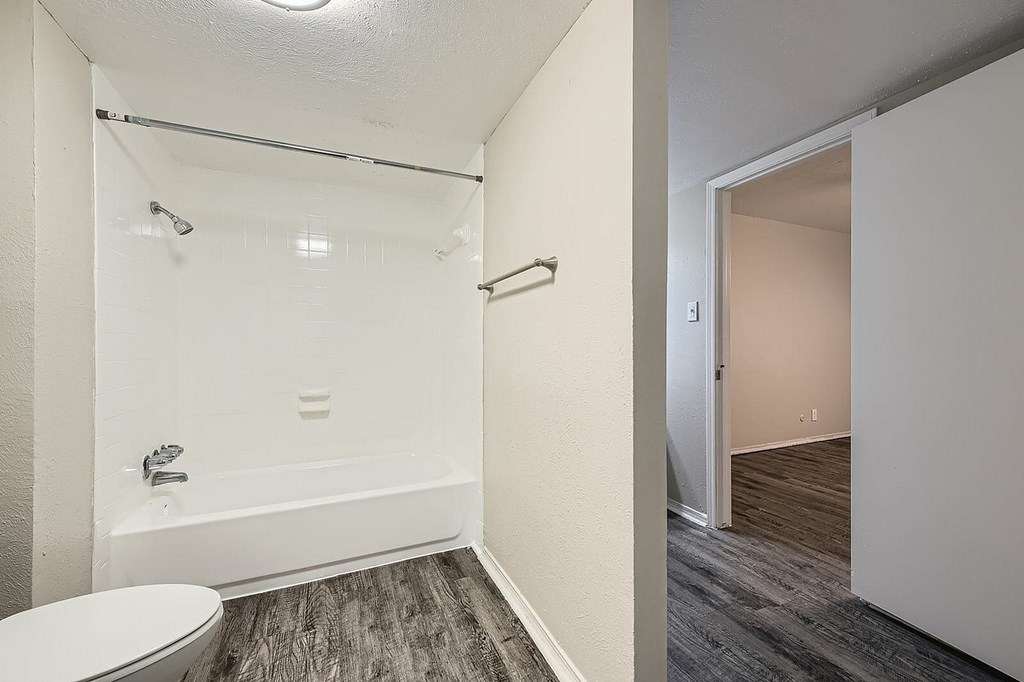 A bathroom with a toilet, tub, and shower.