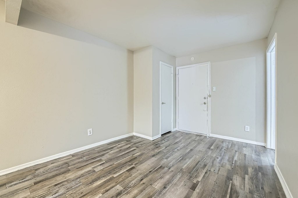 A room with wood flooring and white walls.