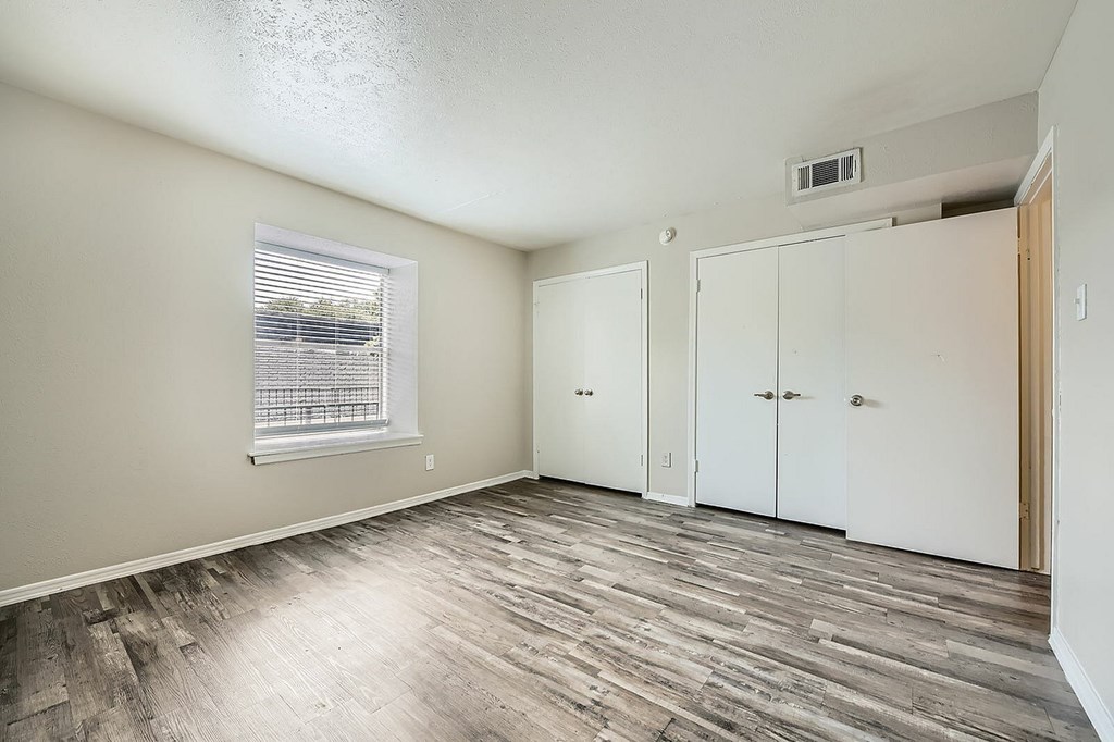 A room with wood flooring and white walls.
