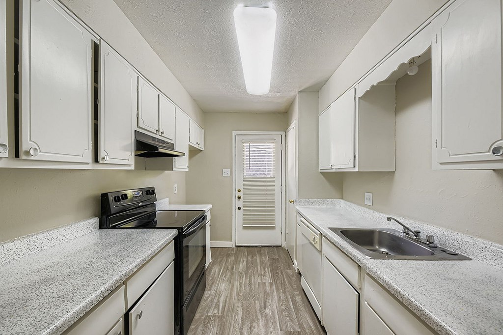 A kitchen with white cabinets and a black stove top oven.