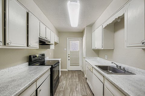 A kitchen with white cabinets and a black stove top oven.