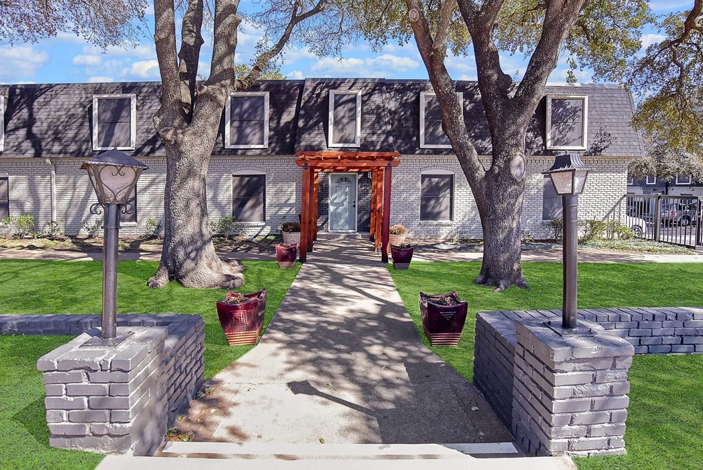 A pathway leads to a building with a red gate.
