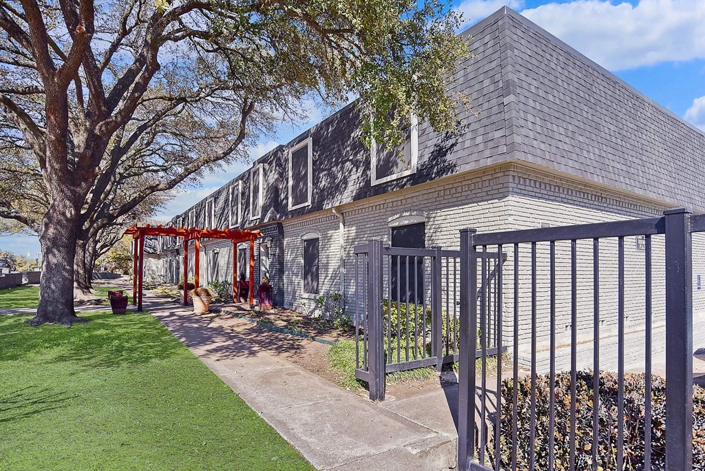 A building with a grey roof and a red gate.