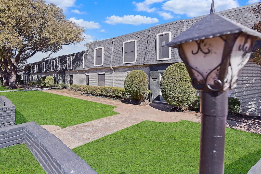 A building with a grey roof and a green lawn in front.
