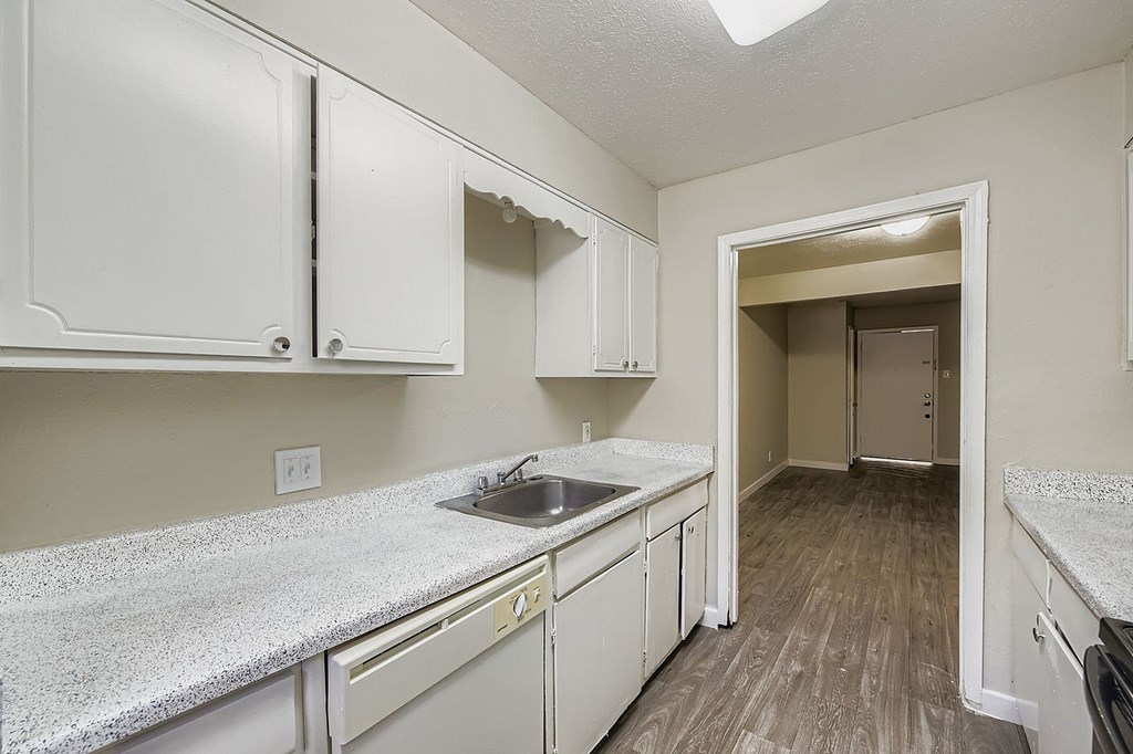 A kitchen with white cabinets and a granite countertop.