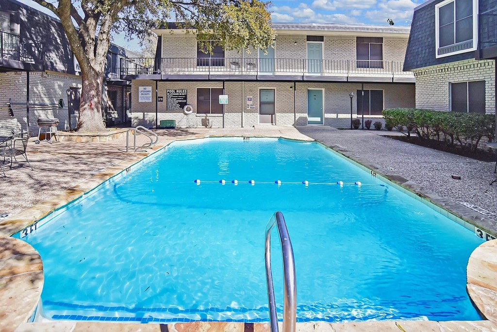 A blue swimming pool in front of a building.