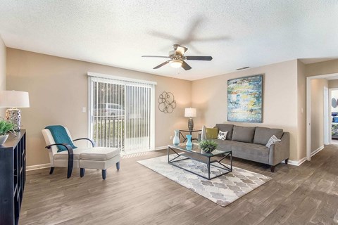 A living room with a couch, chair, and a painting on the wall.