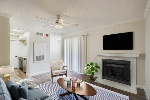 A living room with a fireplace and a television on the wall.