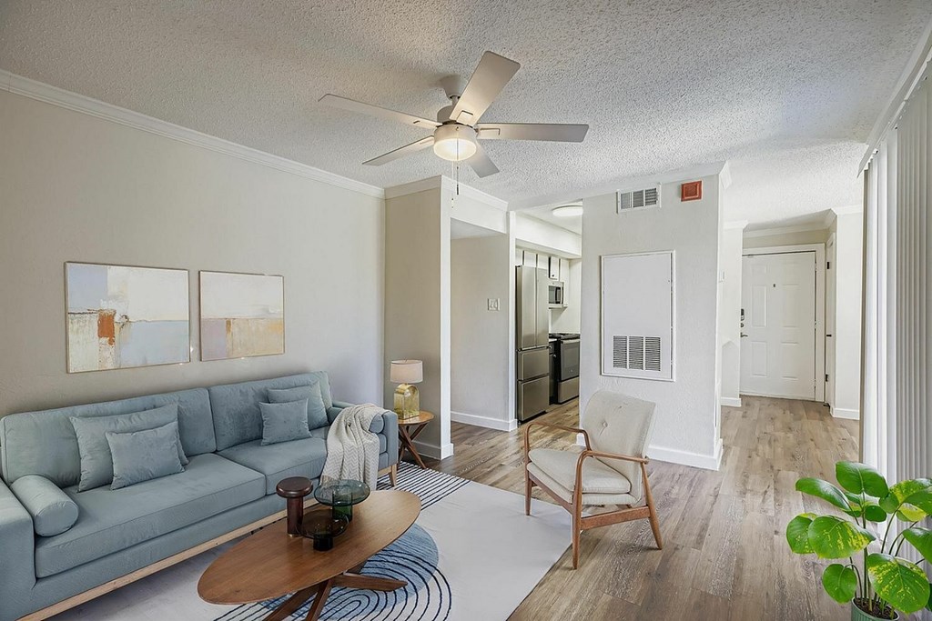 A living room with a blue couch and a wooden coffee table.