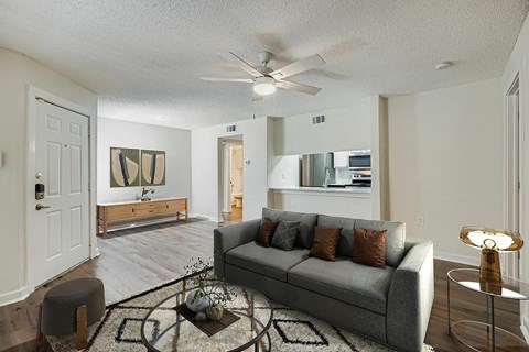 A spacious room with a ceiling fan and wooden flooring.
