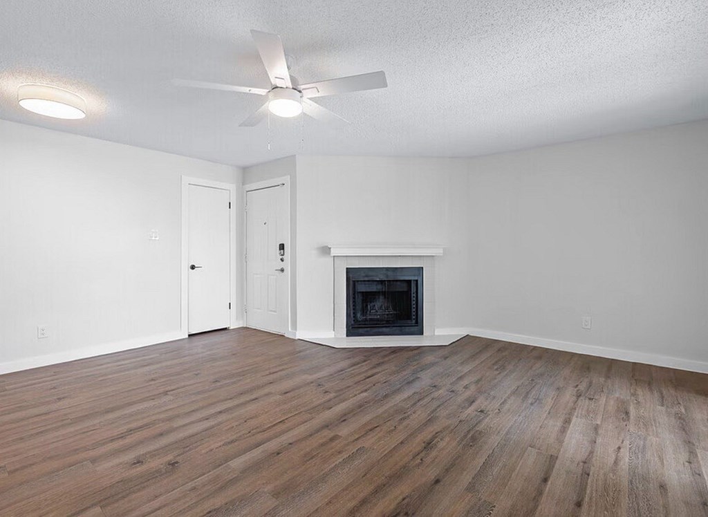 A room with a fireplace and a ceiling fan.