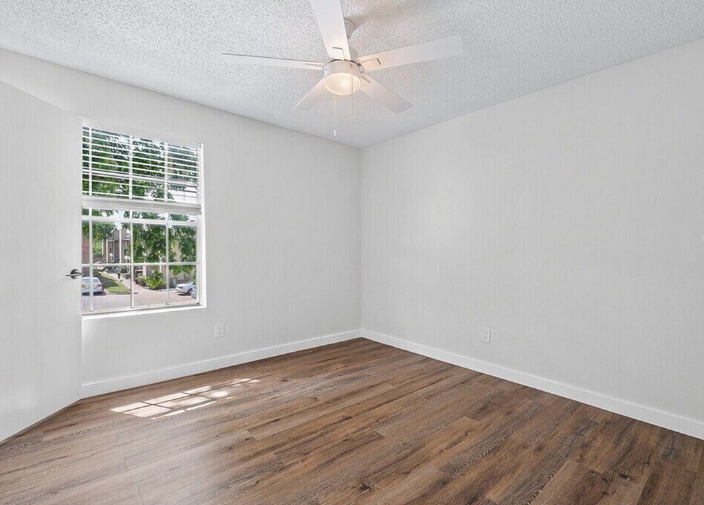 A room with a window and a ceiling fan.