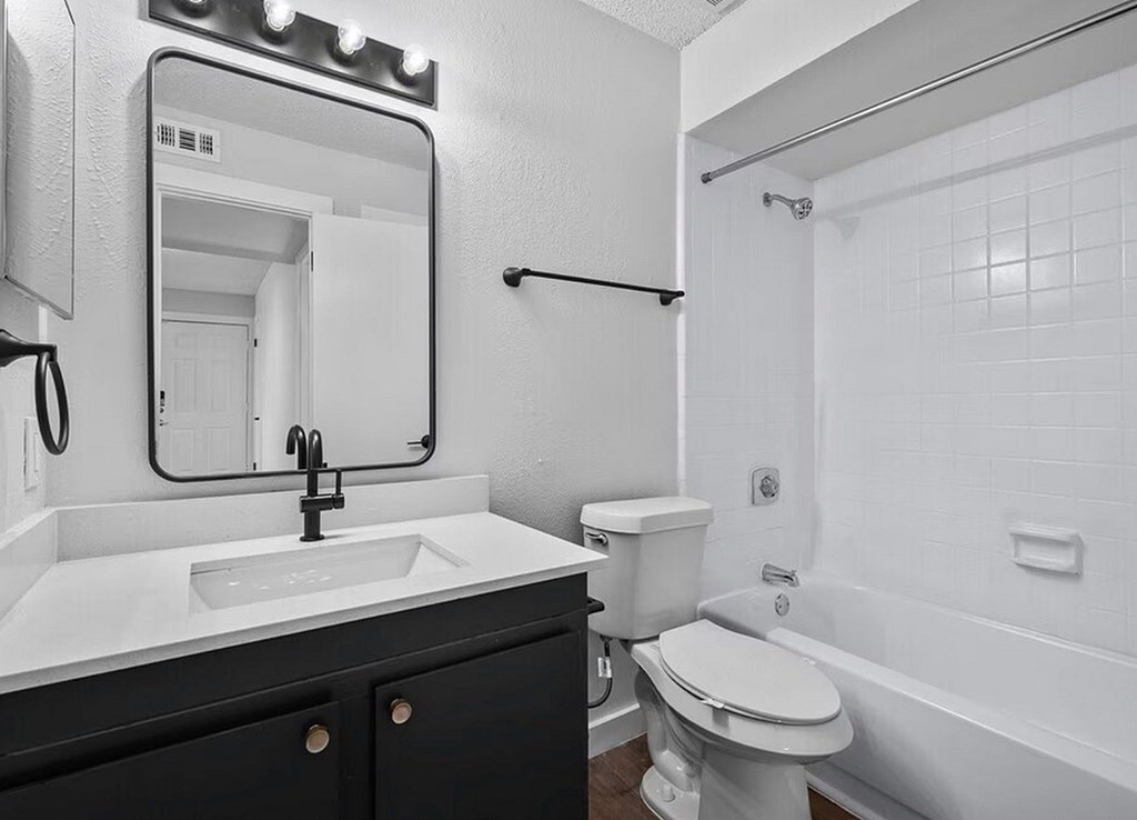 A bathroom with a white sink and toilet.