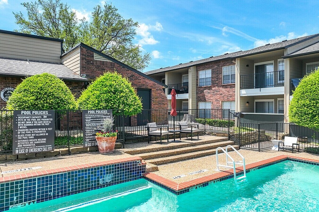 A pool with a sign that says "POOL POLICIES" in front of a building.