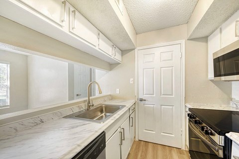 A kitchen with a white counter top and black appliances.