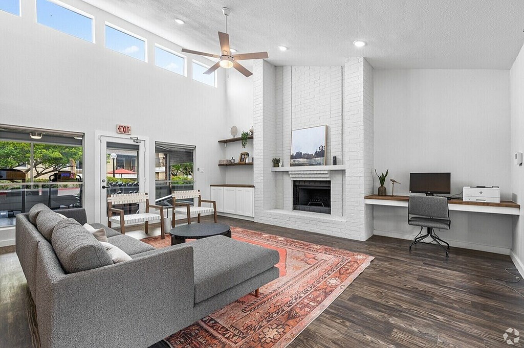 A living room with a grey couch and a fireplace.
