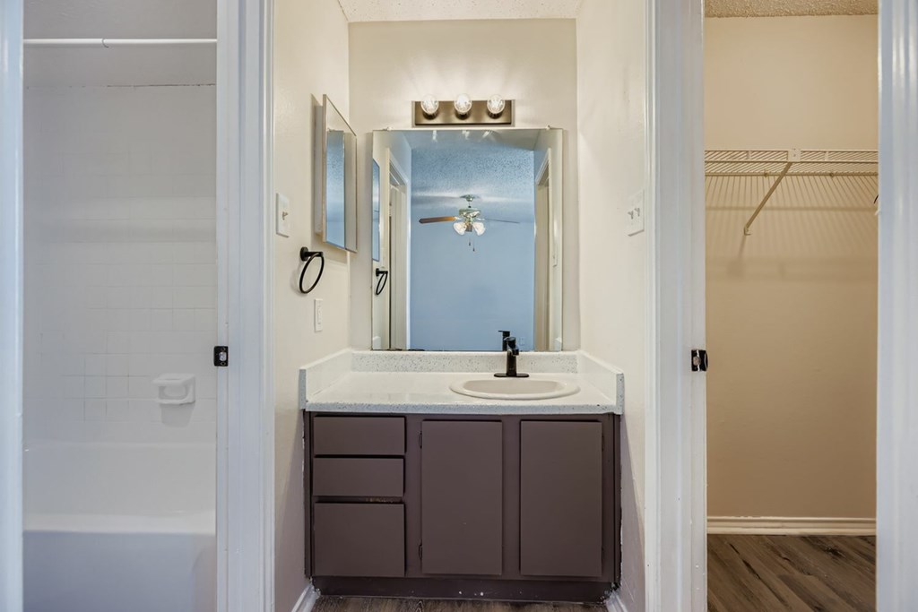 A bathroom with a sink and mirror.