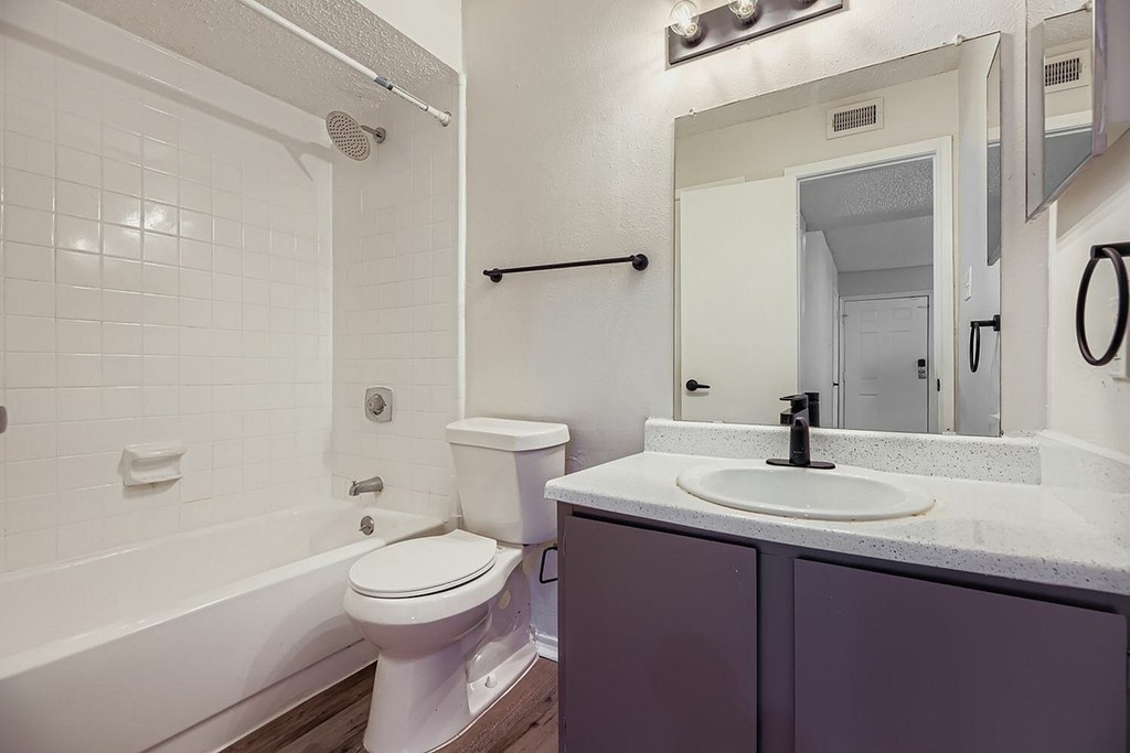 A white toilet sits next to a white sink in a bathroom.