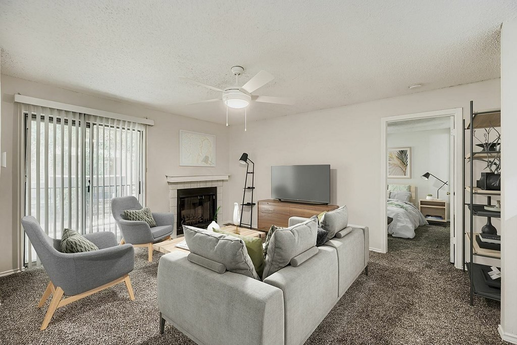 A living room with a grey couch, a fireplace, and a television.