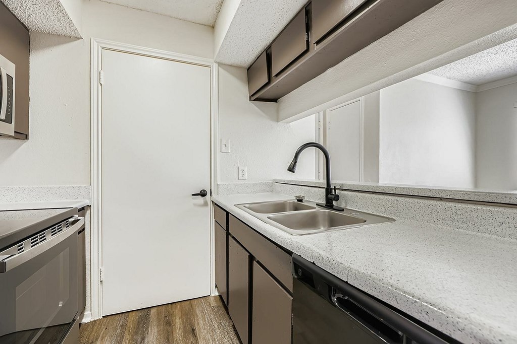 A black stove and refrigerator in a kitchen.