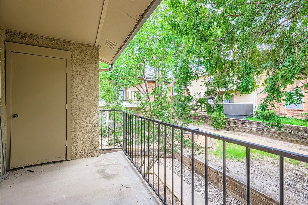 A balcony with a metal railing and a closed door.